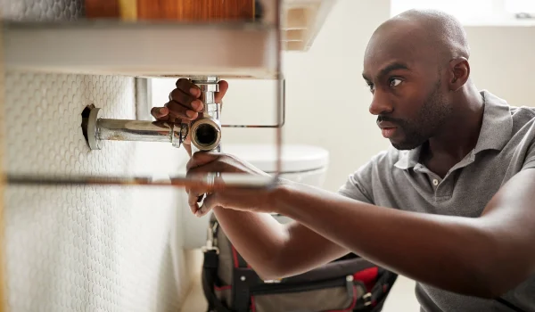 a male plumber fixing a pipe connection from Plumber Georgetown in Georgetown, TX a male plumber fixing a pipe connection from Plumber Georgetown in Georgetown, TX